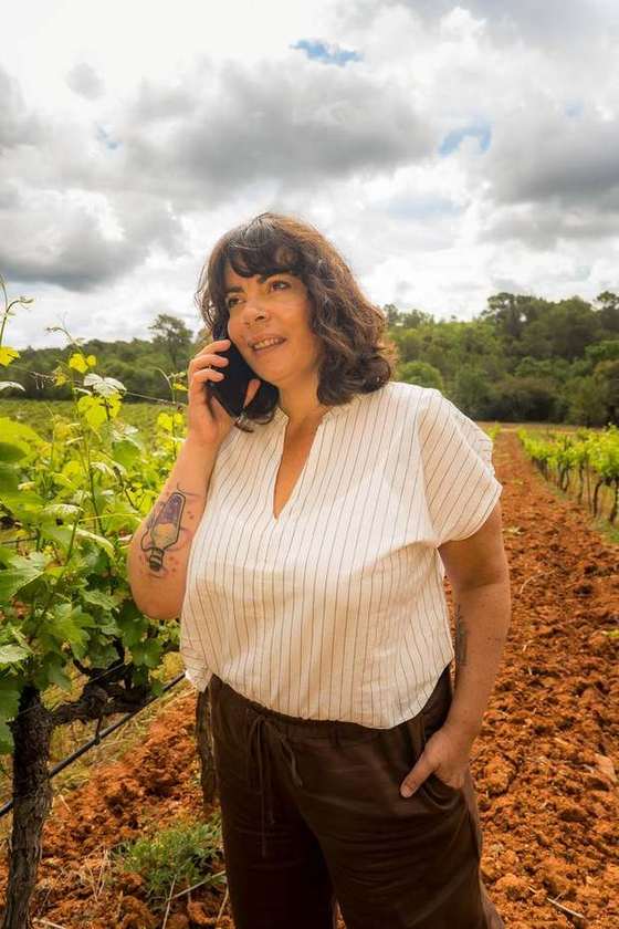 Aurélie Rousseau au téléphone dans une parcelle de vigne